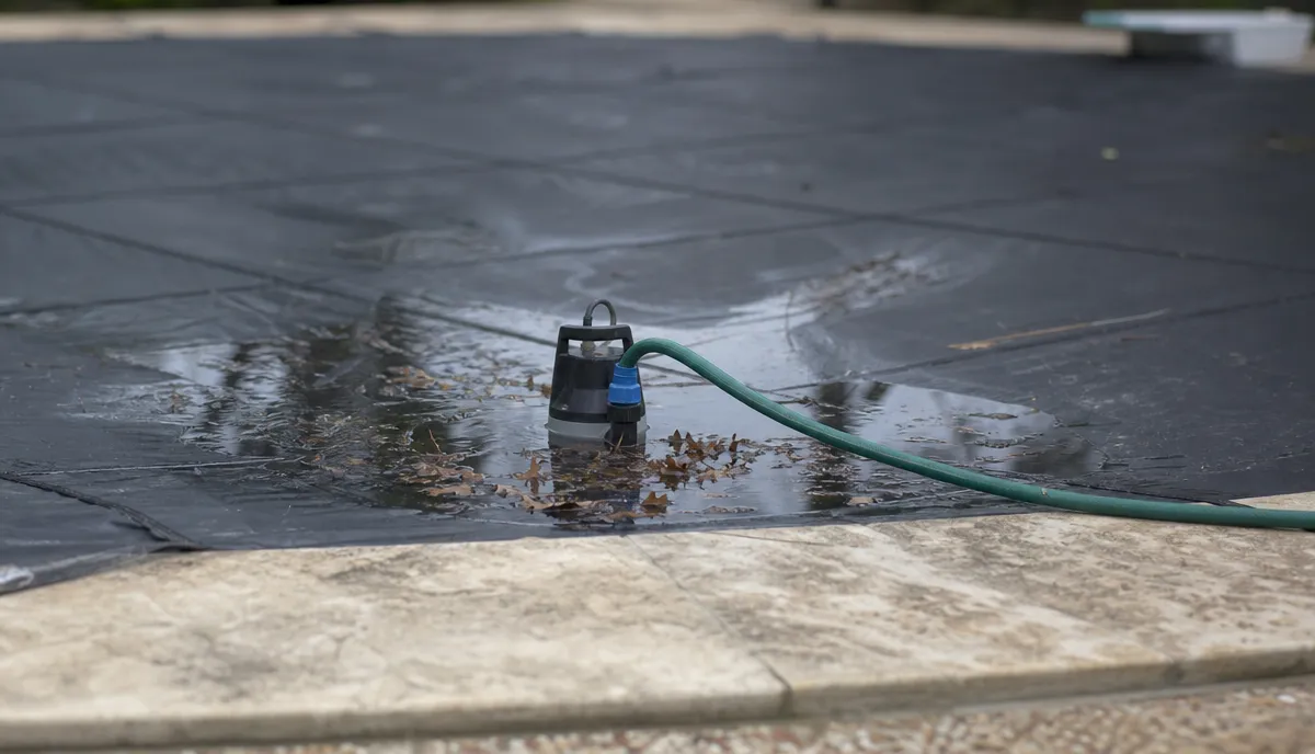 A cover pump sitting in standing water on a solid cover