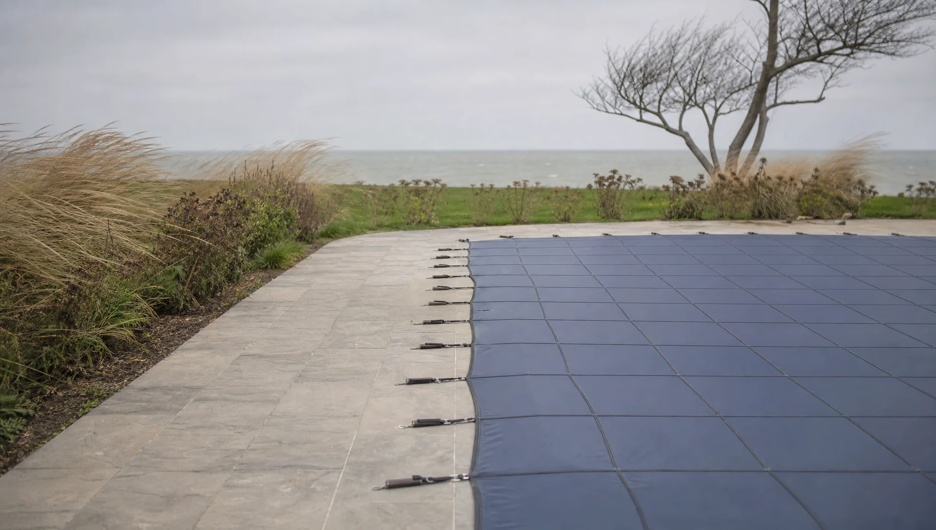 An in-ground pool under a taut custom safety cover